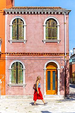 Young woman in front of colorful houses, colorful house facades, Burano Island, Venice, Veneto, Italy, Europe