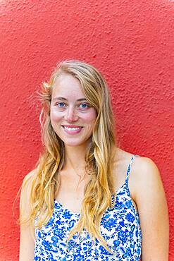 Portrait of a Young Woman in Front of a Red Wall, Burano Island, Venice, Veneto, Italy, Europe