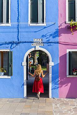 Young woman in front of colorful houses, colorful house facades, Burano Island, Venice, Veneto, Italy, Europe