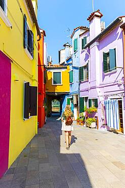 Young woman in front of colorful houses, colorful house facades, Burano Island, Venice, Veneto, Italy, Europe