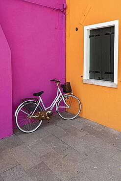 Bicycle leaning against house wall, orange and pink house wall, colorful house wall, colorful facade, Burano Island, Venice, Veneto, Italy, Europe