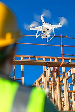 Female pilot flies drone quadcopter inspecting construction site