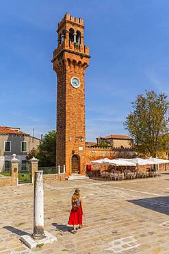 Tourist in red dress in front of St. Stefano bell tower, Murano, Venice, Veneto, Italy, Europe