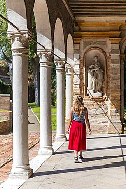 Tourist in red dress in an arcade, Murano Glass Museum, Museo del Vetro, Murano, Murano Island, Venice, Veneto, Italy, Europe