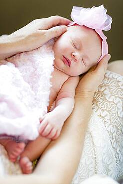 Gentle hands of mother holding her precious newborn baby girl