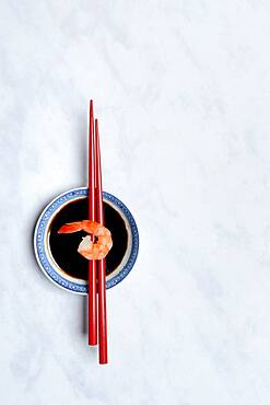 Cooked shrimp on chopsticks and shell with soy sauce, Germany, Europe