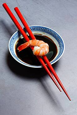 Cooked shrimp on chopsticks and shell with soy sauce, Germany, Europe