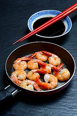 Fried prawns in pan and small bowl with soy sauce, Germany, Europe