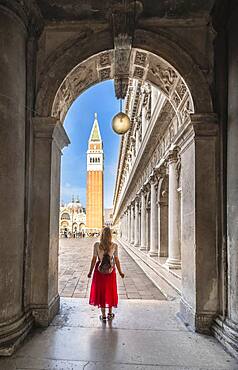 Young woman in portico at St. Mark's Square, with Campanile bell tower, Venice, Veneto, Italy, Europe