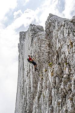 Young man climbing a vertical rock face without a rope, rocky mountains and scree, near Hochkalter, Berchtesgadener Alpen, Berchtesgadener Land, Upper Bavaria, Bavaria, Germany, Europe