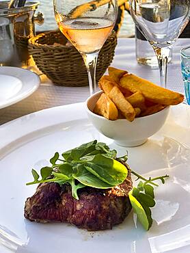 Grilled fillet steak in the evening sun by the sea, Port de Andratx, Majorca, Spain, Europe