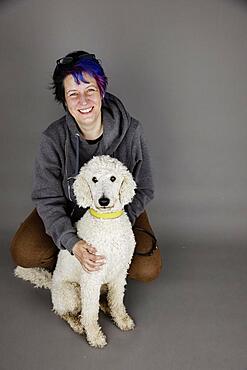 Woman with white king poodle, studio shot, Germany, Europe