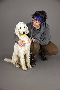 Woman with white king poodle, studio shot, Germany, Europe