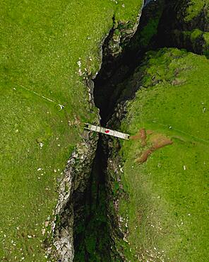 Aerial view, a person standing on a small wooden bridge, Sandvik, Suduroy, Faroe Islands, Europe