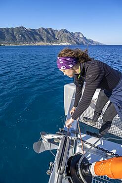 Sailor, young woman sets anchor, sailing on a sailing catamaran, sailing trip, Kos, Dodecanese, Greece, Europe