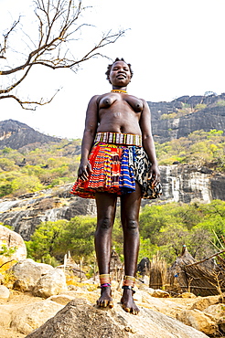 Traditional dressed young girls from the Laarim tribe standing on a rock, Boya hills, Eastern Equatoria, South Sudan, Africa