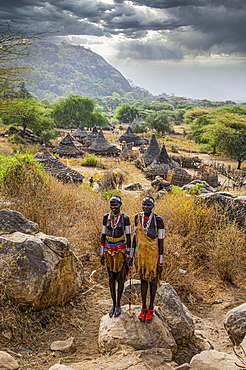 Traditional dressed young girls from the Laarim tribe standing on a rock, Boya hills, Eastern Equatoria, South Sudan, Africa