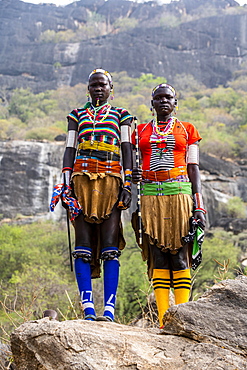 Traditional dressed young girls from the Laarim tribe standing on a rock, Boya hills, Eastern Equatoria, South Sudan, Africa