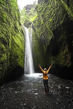 Hiker by a waterfall, river in Nauthusagil Gorge, South Iceland, Iceland, Europe