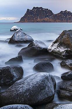 Stormy winter Scandinavian landscape, long exposure, coast, beach, sea, mountains, snow, Uttakleiv strand, Leknes, Nordland, Lofoten, Norway, Europe