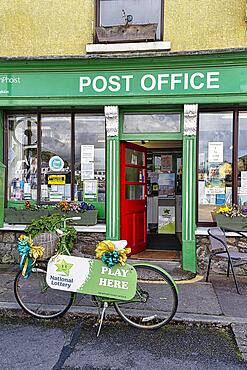 Post Office in Irish national colours, bicycle with advertisement for lottery, Newport, Mayo, Connacht, Ireland, Europe