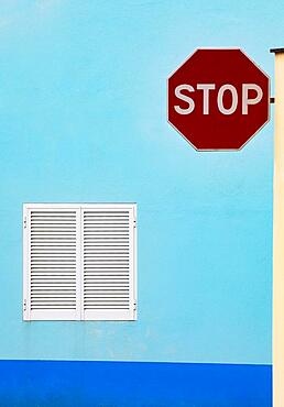 Light blue house facade with closed white shutters and stop sign, Porto Formoso, Sao Miguel Island, Azores, Portugal, Europe