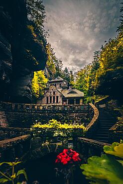 Old gasworks made of solid stone with stone steps in the middle of a gorge with forest and trees. Hrensko Czech Republic