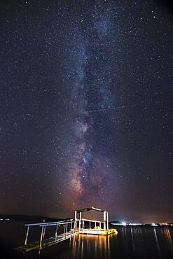 Night view of the Milky Way with illuminated jetty in the foreground, beach, Ouranoupoli, Grichenland, Mediterranean Sea