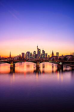 Illuminated skyline with Commerzbank, Hessische Landesbank, Cathedral, Opera Tower, Deutsche Bank, in front the Old Bridge, behind the purple sunset Frankfurt, Hesse, Germany, Europe