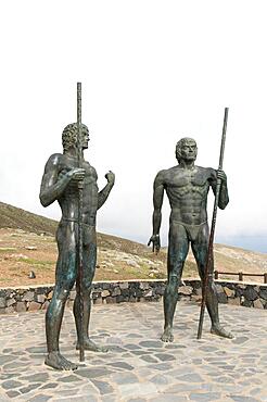 Guanches, ancient Canarians, larger-than-life bronze warrior statues guard the valley Vega de Rio de las Palmas, on the road to Betancuria, Fuerteventura, Canary Islands, Spain, Europe