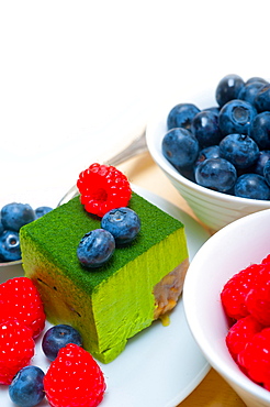 Green tea matcha mousse cake with raspberries and blueberries on top