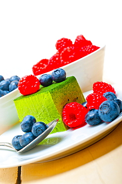 Green tea matcha mousse cake with raspberries and blueberries on top