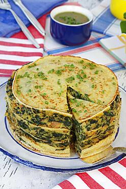 Swabian cuisine, spinach cake spoon style with pancakes, Flaedle layered, pancake cake on plate, herb sauce in the back, sauce, Swabian speciality, Germany, Europe