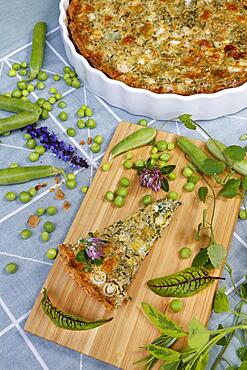 Southern German cuisine, baking, hearty vegetable cake with walnut base, peas, wild herbs and spring onions, quiche dish, tart dish, ceramic baking dish, wooden board, Germany, Europe