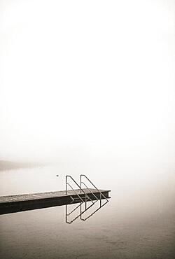 Empty bathing jetty in the morning mist at Irrsee, sepia colours, autumn landscape, Salzkammergut, Upper Austria, Austria, Europe