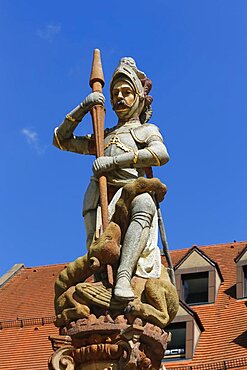 Georgsbrunnen eastern Muensterplatz, figure of St. George, dragon is stabbed with lance, patron saint, behind house, building, roof, tile, Ulm, Baden-Wuerttemberg, Germany, Europe