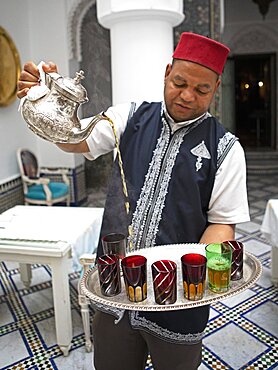 Man pouring tea into a glass, Fes, Morocco, Africa