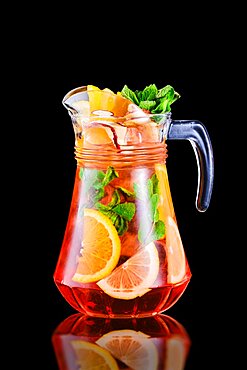 Pitcher with refreshing cold sangria isolated on black background