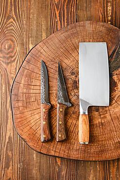 Top view of cleaver and knives on wooden stump