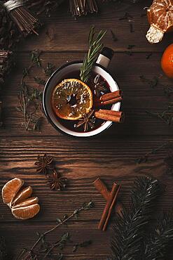 Christmas hot drink mulled wine on wooden background with cinnamon, cloves, spices