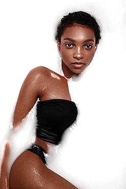 Beautiful african american woman with classic makeup in milk bath. Beauty face