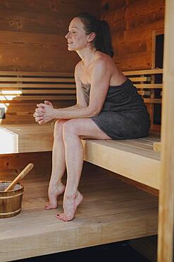 Woman sitting in Finnish sauna