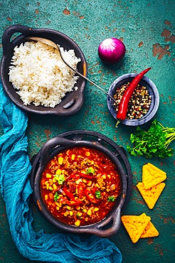 Hot Mexican Chili con carne with rice and tortilla chips and spices