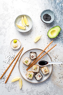 Tuna and avocado sushi wrapped in sesame seeds with ingredients