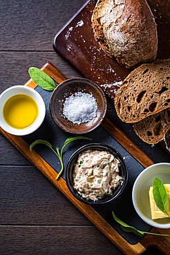 Spelt bread with homemade tuna spread, olive oil and salt on wooden background