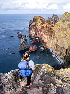 Hiker, coastal landscape, cliffs and sea, Miradouro da Ponta do Rosto, rugged coastline with rock formations, Cape Ponta de Sao Lourenco, Madeira, Portugal, Europe