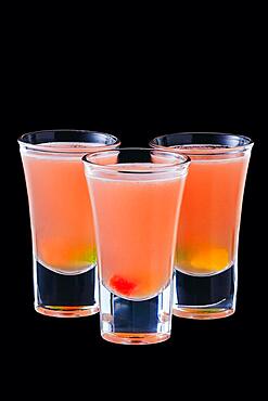 Three vodka shots with sweet jelly isolated on black background