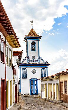 Street with cobblestones and colonial-style houses with a historic church in the background in the famous city of Diamantina in Minas Gerais, Brasil