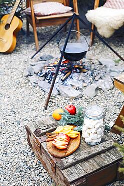 From above traditional mulled wine with slices of orange preparing in pot over burning logs in winter in countryside