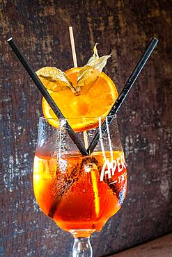 Cocktail Glass with Hugo Drink and Two Straws Brown Background